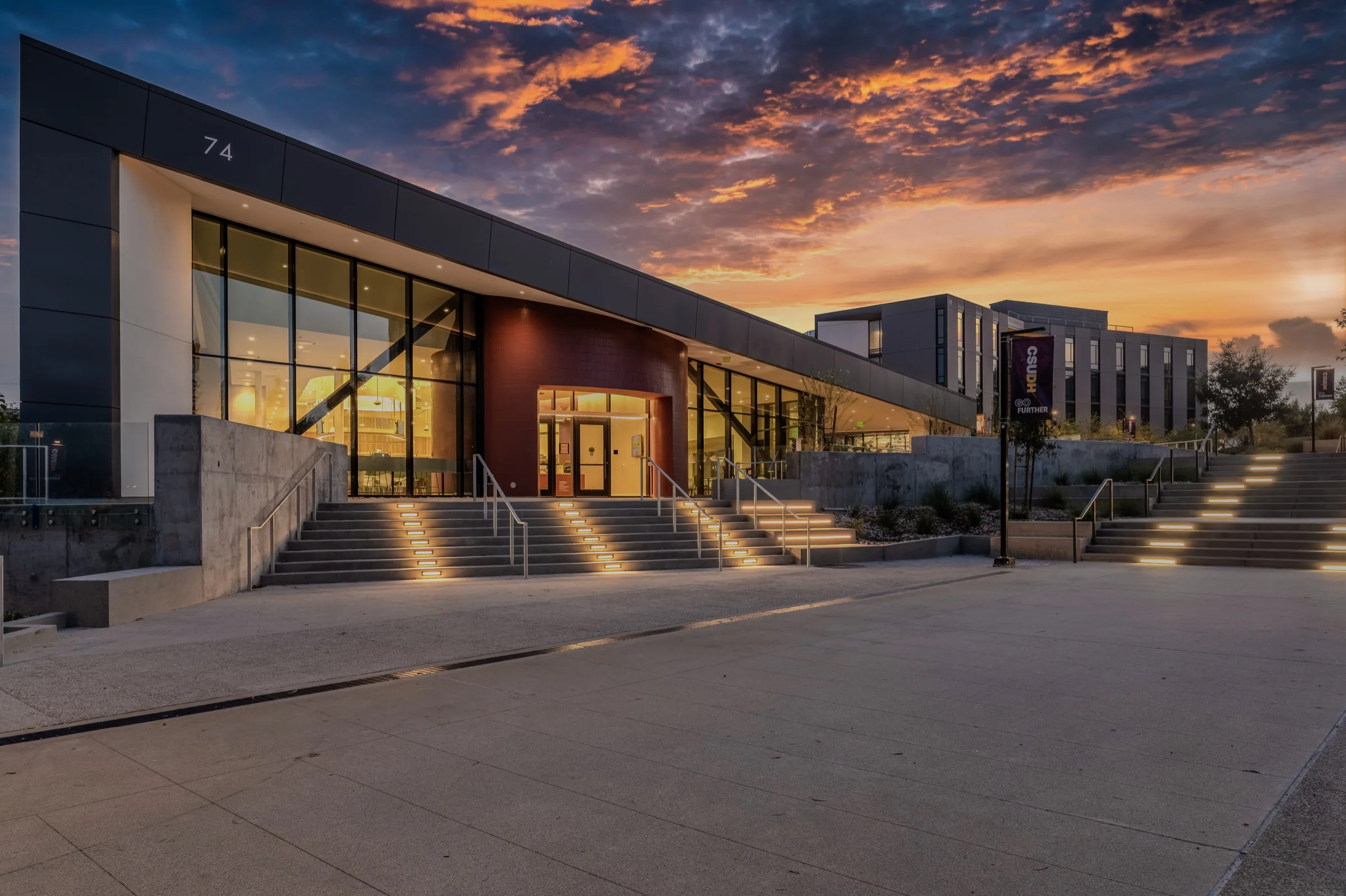 AJK Construction completed dining commons exterior at Cal State Dominguez Hills beneath a dramatic sunset sky