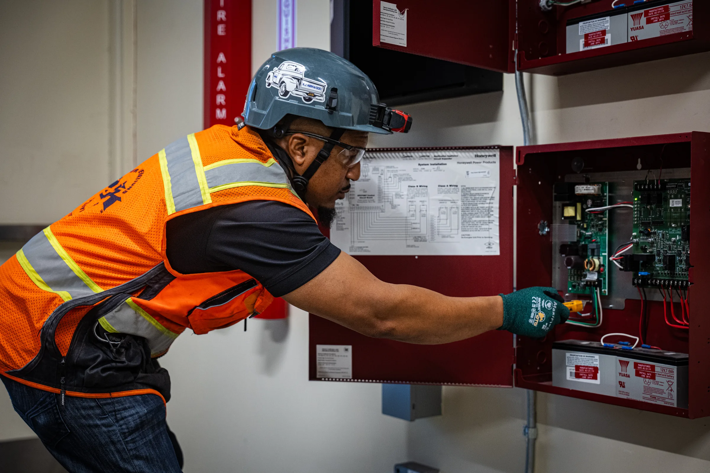 AJK technician inspecting a fire alarm control system