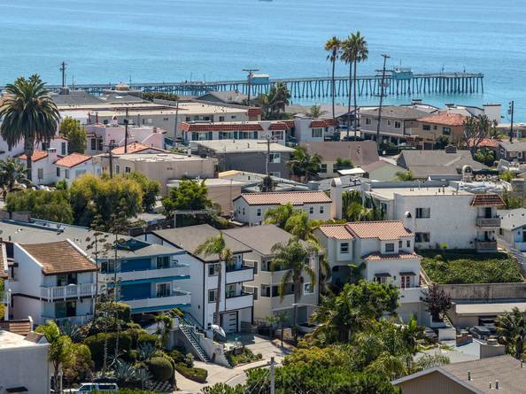 Aerial view over San Clemente rooftops toward the pier and the Pacific Ocean.