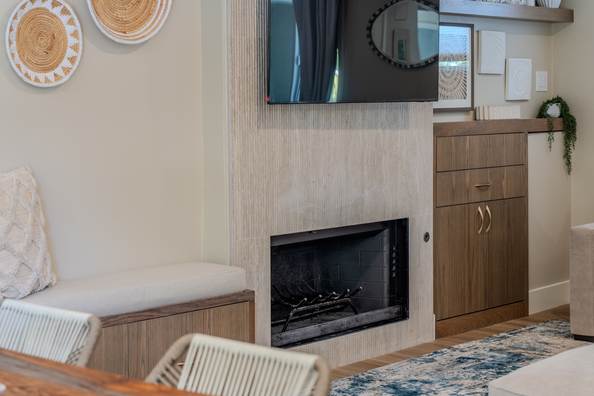 Living room fireplace with a tiled surround, floating shelves and a wall mounted screen.