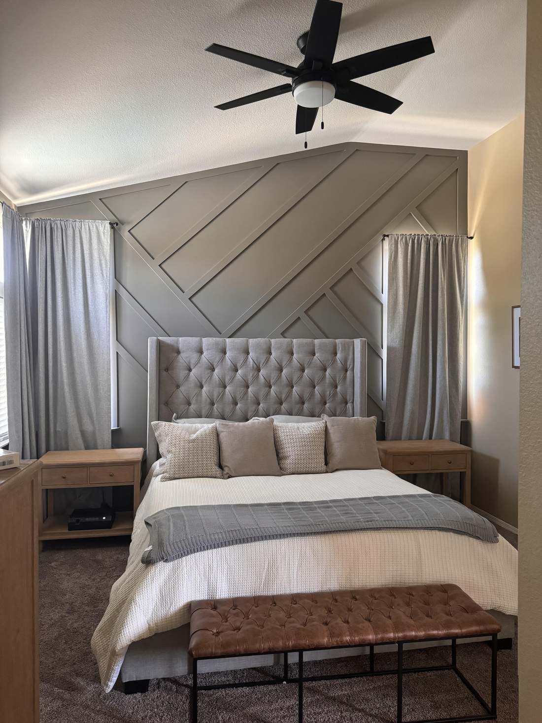 Geometric wood accent wall behind an upholstered bed