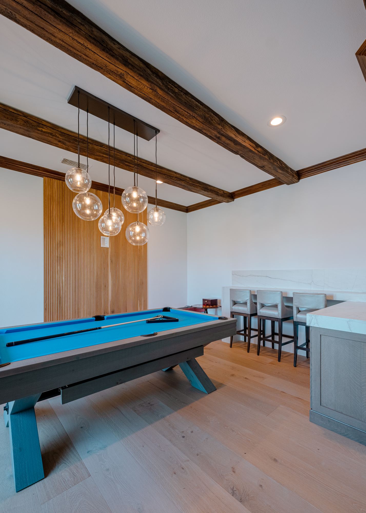 Game room with exposed beams, oak paneling and built in bar seating