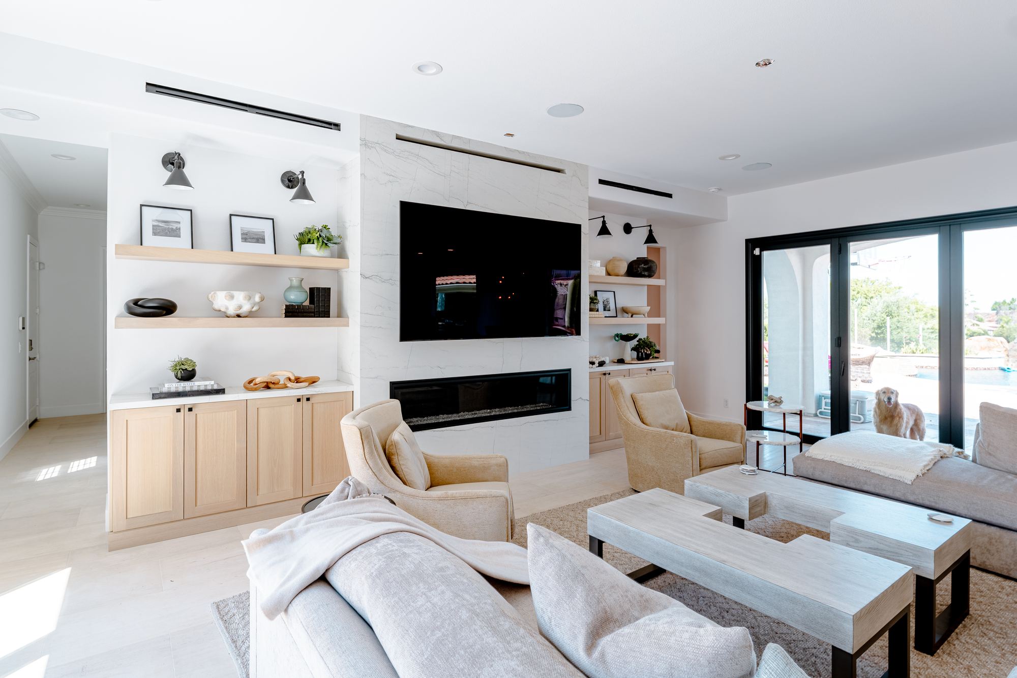 Living room with a linear firebox, floating shelves and full height sliding doors
