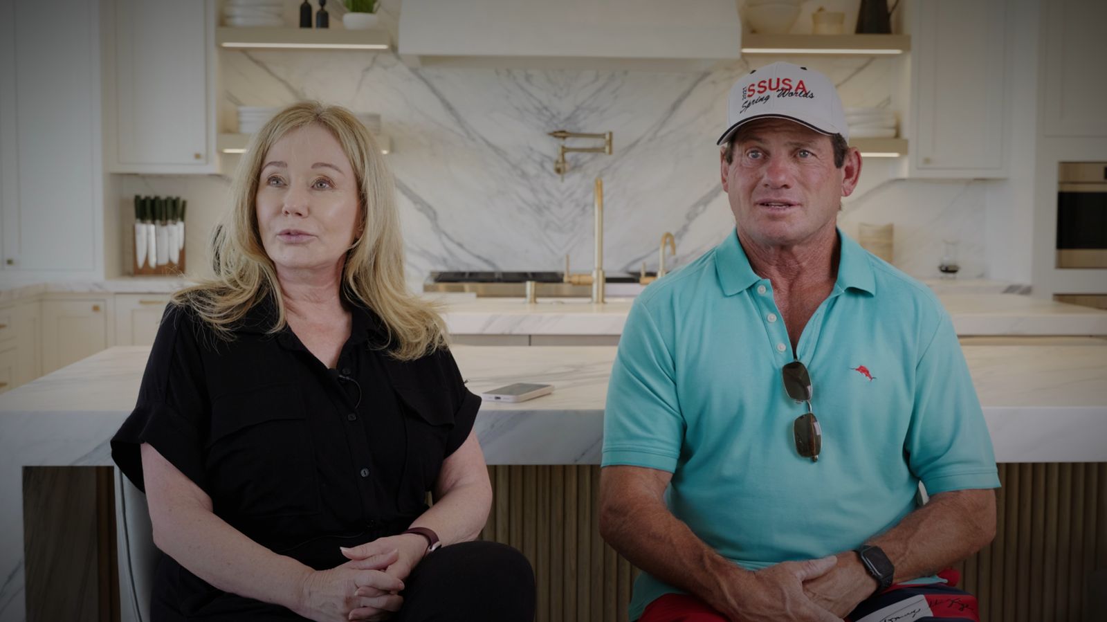 The homeowners seated at the kitchen island, filmed for a testimonial