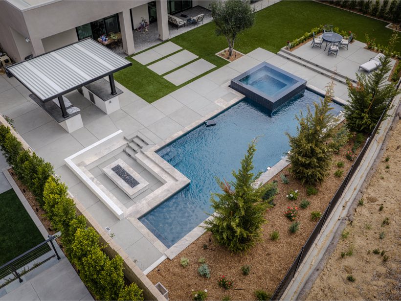 Aerial of a modern estate backyard with pool, raised spa and pavilions