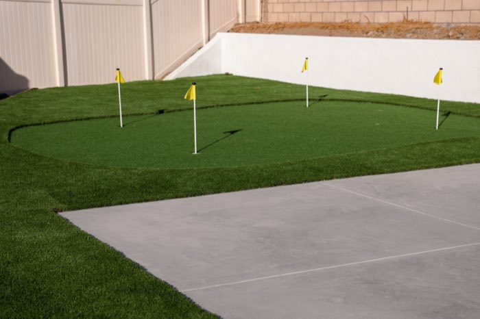 Backyard putting green with flags and artificial turf