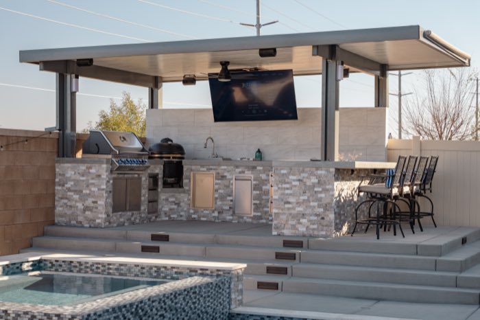 Covered pavilion with outdoor kitchen, TV and bar seating