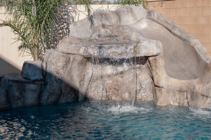 Rock grotto waterfall with a built-in slide