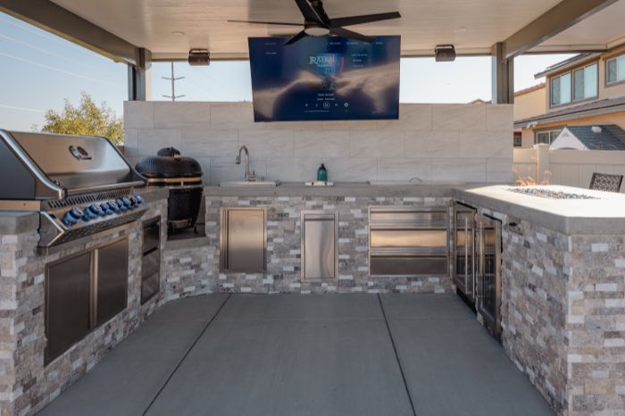 Outdoor kitchen with built-in grill and stone bar