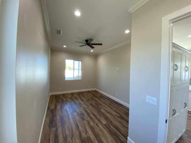 A finished ADU bedroom with a ceiling fan, recessed lighting and LVP flooring.