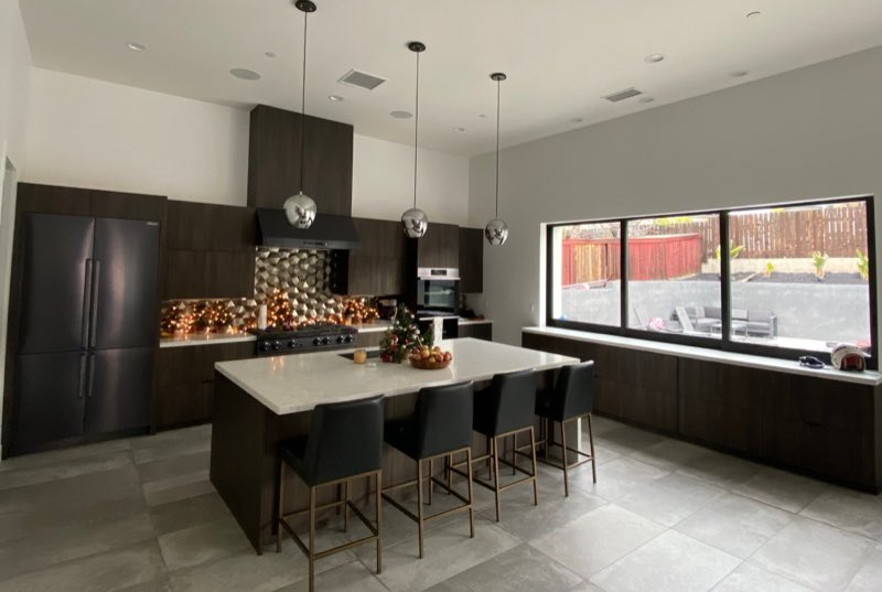 A finished modern kitchen in a custom built home with clean lines and integrated appliances.