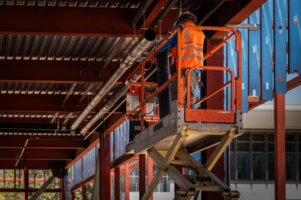 Pro-Craft craft worker installing overhead piping at Crafton Hills College